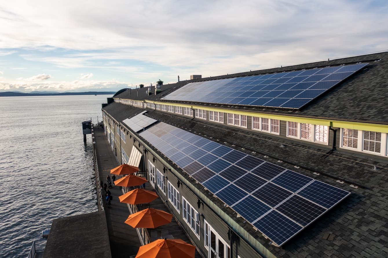 An overhead shot of the Seattle Aquarium's Pier 59 building, showing the long stretches of solar panels installed on the roof.