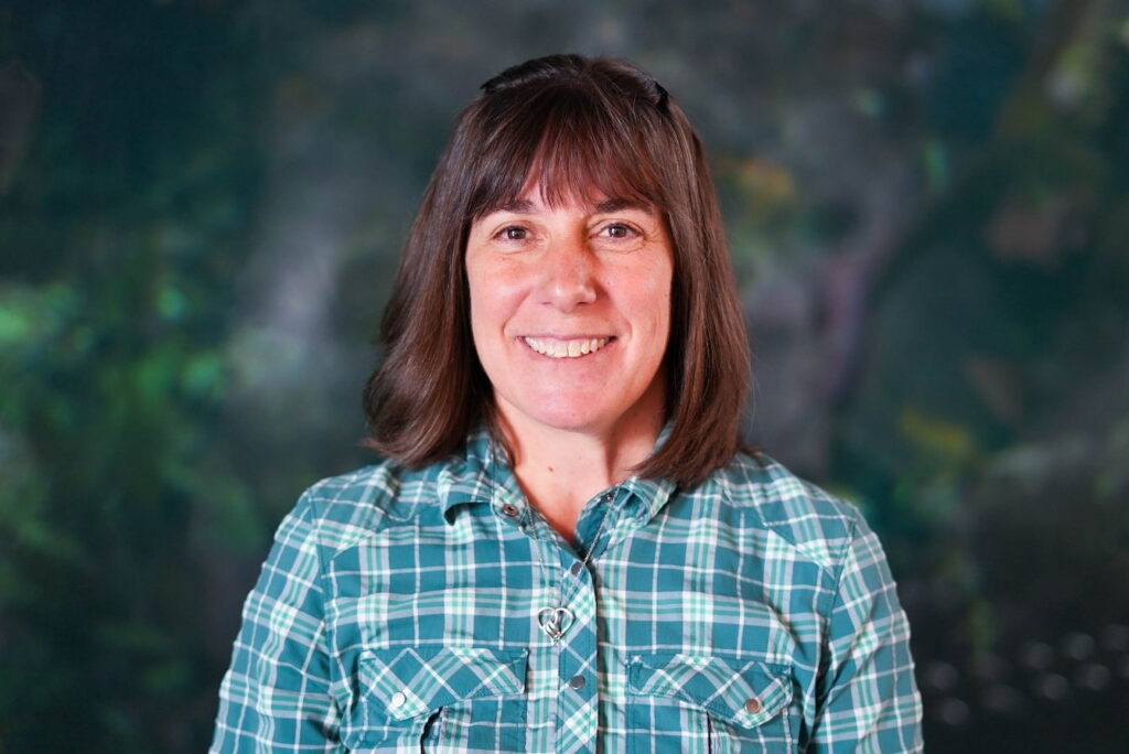 Lisa Hartman, a woman with shoulder-length brown hair wearing a checkered blue shirt.