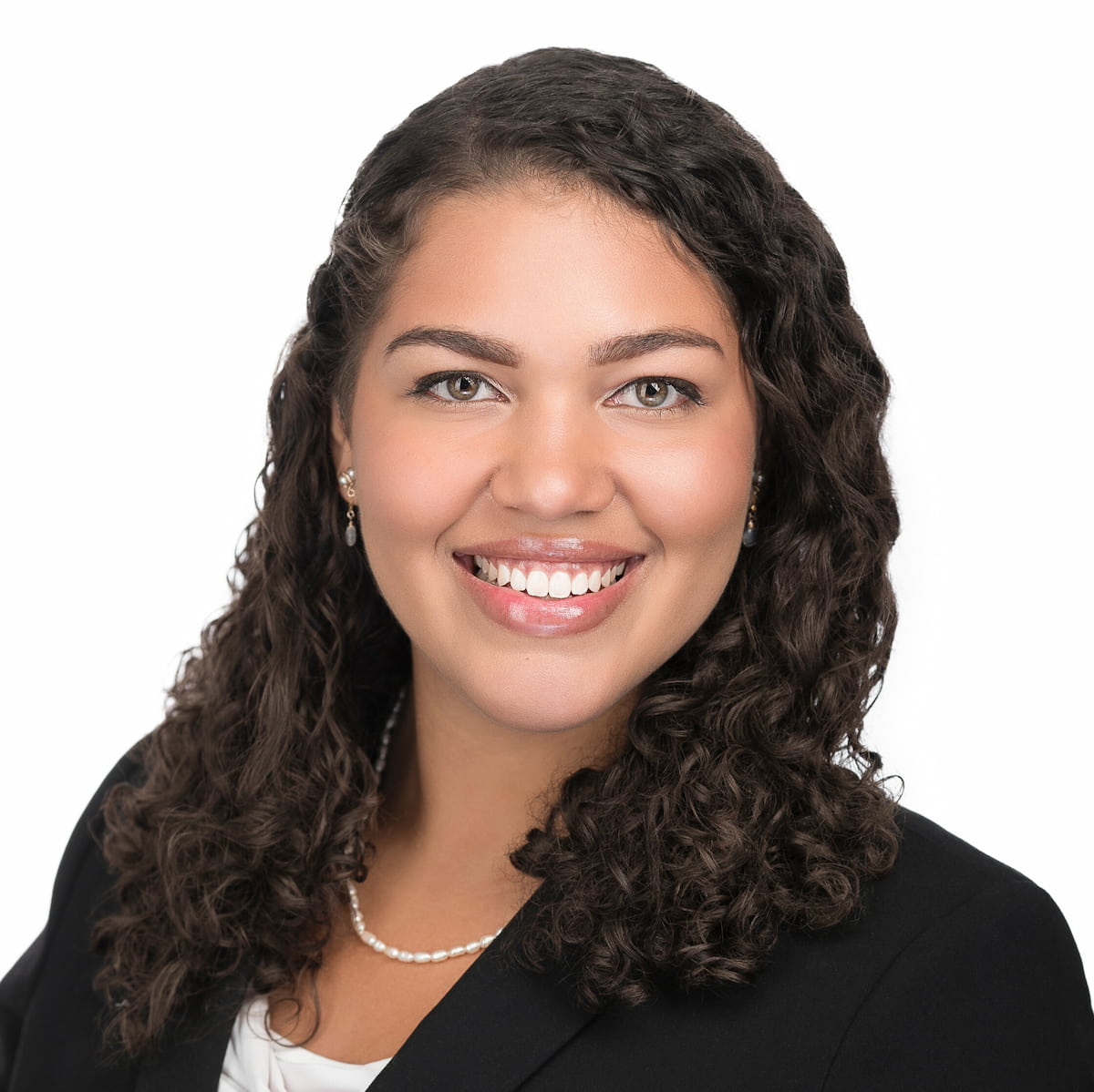 A headshot of Jasmine Prat. She has dark, shoulder-length curly hair.