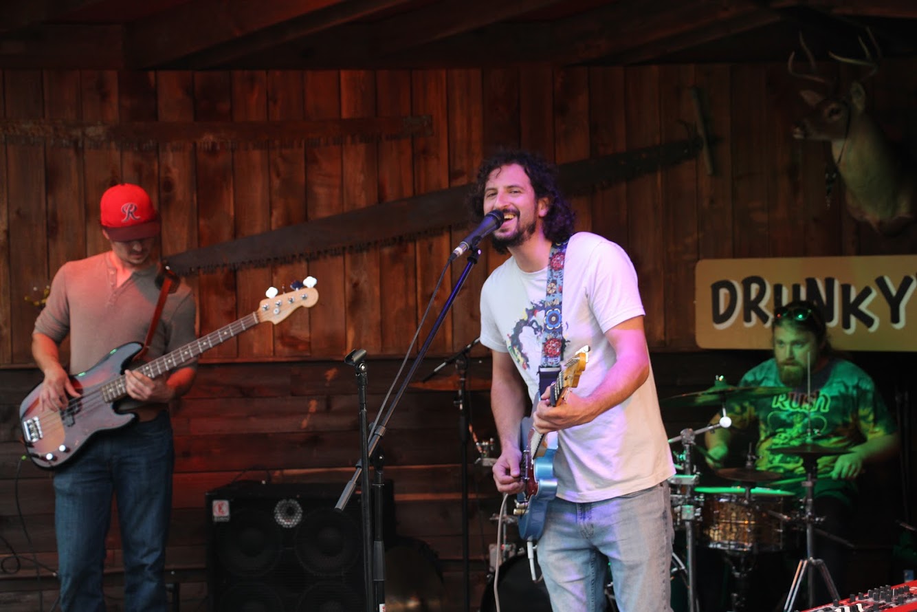 Judd Wasserman performing with a guitar on a stage.