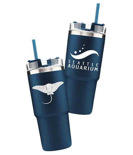 A drink tumbler with the Seattle Aquarium logo on one side and a second image of the tumbler with an eagle ray illustration the opposite side.