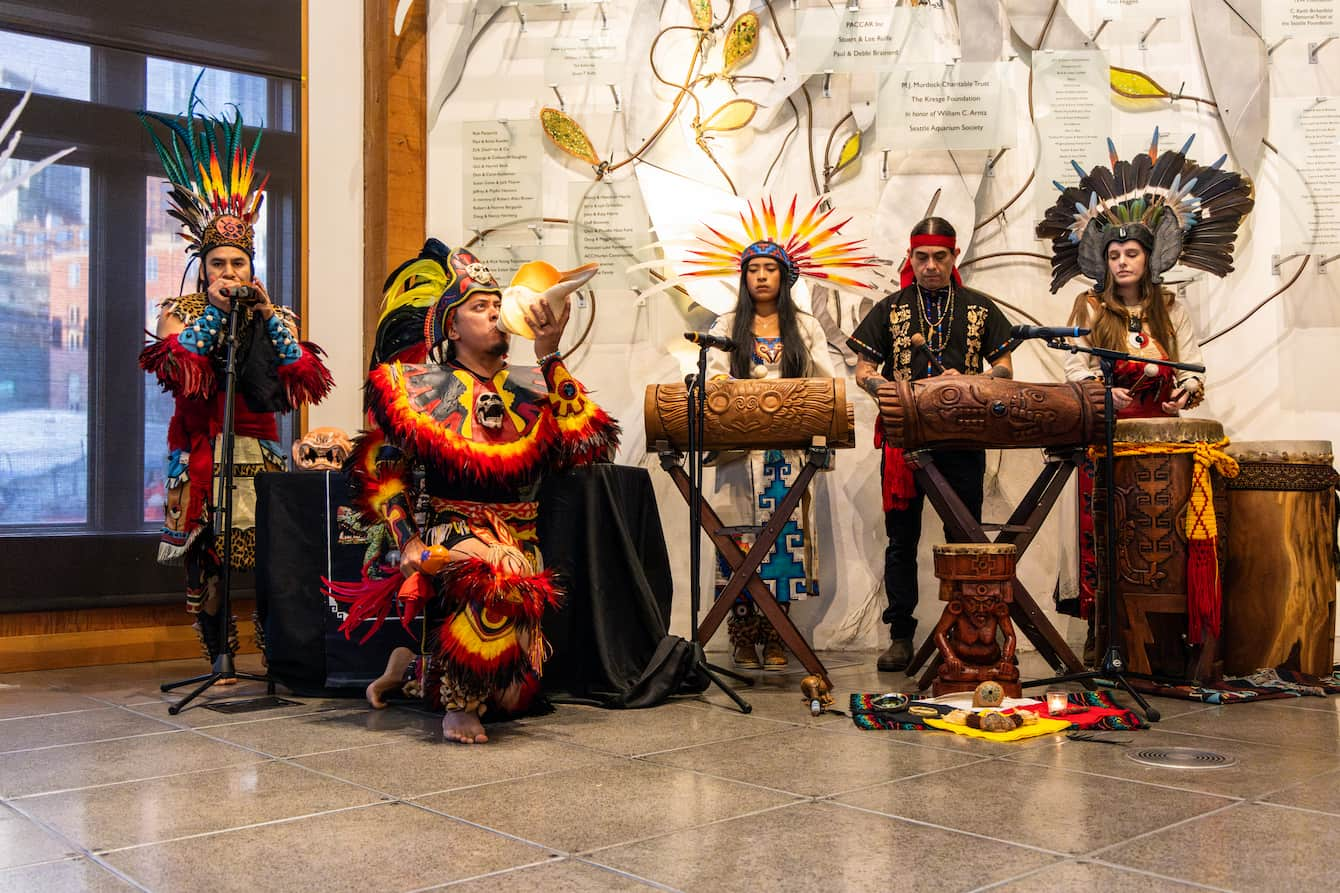 Members of TLALOKAN dance group performing music in the Aquarium's Puget Sound Hall.