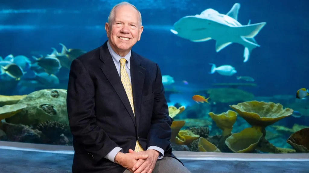 Bob Davidson sitting in front of The Reef habitat in Ocean Pavilion.